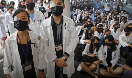 Staf medis menggunakan perban di mata dan masker dalam protes menentang kebrutalan polisi di sebuah rumah sakit di Hong Kong, Selasa (13/8).