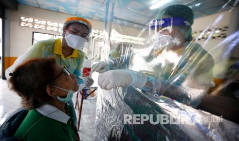 Staf medis mengumpulkan sampel dari rongga hidung dan tenggorokan orang untuk menguji virus korona