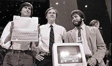 Steve Jobs (kiri), John Sculley (tengah), presiden dan CEO Apple, serta Steve Wozniak, salah satu pendiri Apple, memperlihatkan komputer Apple II di San Francisco pada 4 April 1984.