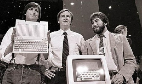 Steve Jobs (kiri), John Sculley (tengah), presiden dan CEO Apple, serta Steve Wozniak, salah satu pendiri Apple, memperlihatkan komputer Apple II di San Francisco pada 4 April 1984.