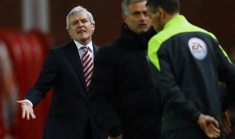 Stoke City manager Mark Hughes (L) reacts as Chelsea manager Jose Mourinho (C) speaks to the fourth official after a tackle from Stoke City's Phillip Bardsley on Chelsea's Eden Hazard during their English Premier League soccer match at the Britannia Stadiu