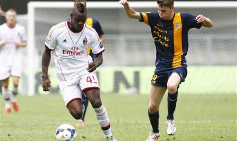 Striker AC Milan, Mario Balotelli (kiri), dibayang-bayangi bek Verona, Jorginho.