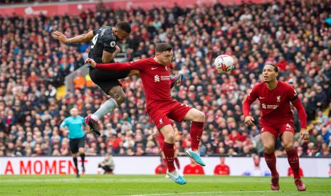 Striker Arsenal Gabriel Jesus (kiri) menanduk bola untuk membawa timnya unggul 2-0 atas Liverpool pada babak pertama lanjutan Liga Primer Inggris 2022/2023 di Anfield, Ahad (9/4/2023). 