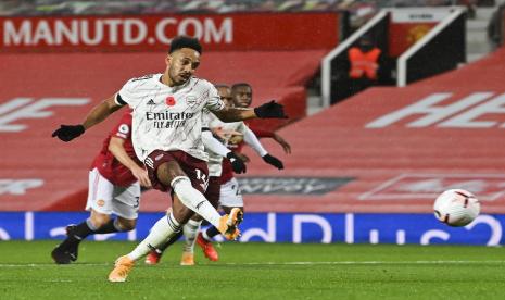 Striker Arsenal, Pierre-Emerick Aubameyang mengeksekusi penalti pada laga melawan Manchester United di Old Trafford, Senin (2/11) dini hari WIB. Arsenal menang 1-0.