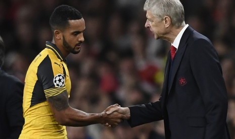 Gelandang Arsenal, Theo Walcott (kiri) bersalaman dengan pelatihnya, Arsene Wenger saat ditarik ke luar pada laga Grup A Liga Champions, di stadion Emirates, London, Kamis (29/9) dini hari WIB. Walcott mencetak dua gol kemenangan Arsenal atas Basel.