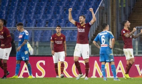 Striker AS Roma, Edin Dzeko (tengah) merayakan kemenangan timnya atas Napoli pada laga Serie A di Stadion Olimpico, Sabtu (2/11).