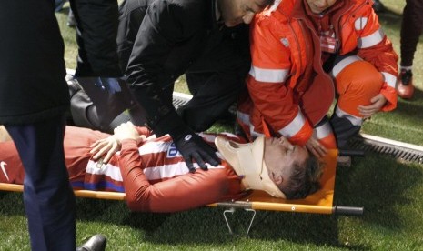 Striker Atletico Madrid, Fernando Torres ditandu ke luar lapangan pada laga La Liga lawan Deportivo La Coruna, di stadion Riazor, Jumat (3/3). Torres mengalami trauma kepala.