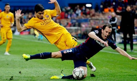 Striker Barcelona, Luis Suarez (kiri) saat berduel dengan bek Atletico Madrid, Diego Godin pada laga Liga Champions di Vicente Calderon,14 April 2016. Godin menyebut Suarez striker terbaik dunia.