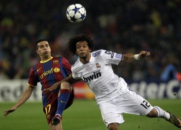 Striker Barcelona, Pedro Rodriguez (kiri), berebut bola dengan bek Real Madrid, Marcelo.