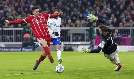 Striker Bayern Muenchen, Robert Lewandowski (kiri) saat mencetak gol ke gawang Schalke 04, Sabtu (10/2).