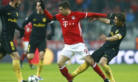 Striker Bayern Muenchen, Robert Lewandowski (tengah) dikawal beberapa pemain Atletico Madrid pada laga Liga Champions di Allianz Arena, Rabu (7/12) dini hari WIB. Lewandowski mencetak satu-satunya gol pada laga itu.