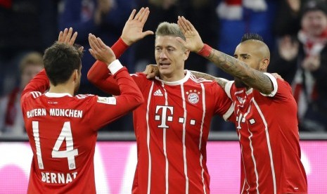 Striker Bayern Muenchen, Robert Lewandowski (tengah) merayakan gol bersama rekannya ke gawang Augsburg pada laga Bundesliga di Allianz Arena, Ahad (19/11) dini hari WIB. Muenchen menang 3-0.