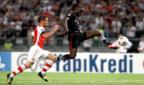 Striker Besiktas, Demba Ba (kanan), berebut bola dengan pemain Arsenal, Mathieu Debuchy, dalam leg pertama babak playoff Liga Champions di Istanbul, Turki, Selasa (19/8). 