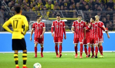 Striker Borussia Dortmund, Pierre-Emerick Aubameyang (kiri) menunggu kickoff saat para pemain Bayern Muenchen merayakan gol Robert Lewandowski (kedua kiri) pada laga Bundesliga di Signal Iduna Park, Ahad (5/11) dini hari WIB. Muenchen menang 3-1 pada laga ini.