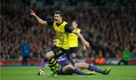 Striker Borussia Dortmund, Robert Lewandowski, merayakan golnya usai menjebol gawang Arsenal di laga Grup F Liga Champions di Stadion Emirates, London, Selasa (22/10).