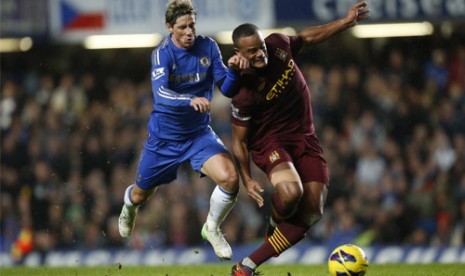 Striker Chelsea Fernando Torres, kiri, berberut bola dengan Vincent Kompany (Manchester City) dalam pertandingan Liga Inggris antara Chelsea dan Manchester City di Stamford Bridge, London, Ahad (25/11).