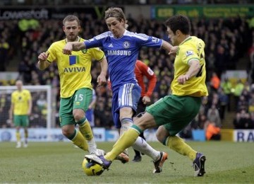 Striker Chelsea, Fernando Torres (tenga), dikepung pemain Norwich City, David Fox (kiri) dan Russell Martin, dalam laga Liga Primer Inggris di Stadion Carrow Road, Norwich, Sabtu (21/1). 