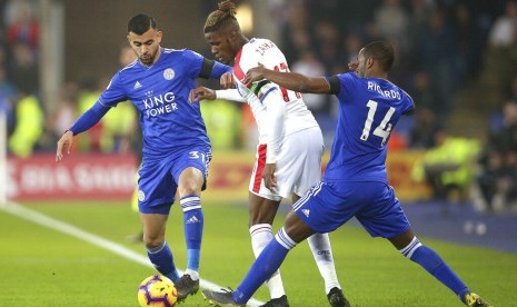 Striker Crystal Palace, Wilfried Zaha (tengah) dikawal dua pemain Leicester City, Rachid Ghezzal (kiri) dan Ricardo Pereira pada laga Liga Primer di Stadion King Power, Ahad (24/2) dini hari WIB. Leicester kalah 1-4.