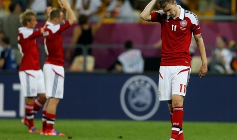 Striker Denmark Nicklas Bendtner (kanan) berjalan lesu setelah timnya tersingkir dari Piala Eropa 2012