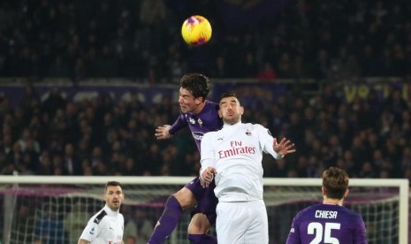 Striker Fiorentina, Dusan Vlahovic (kiri) berebut bola di udara dengan bek AC Milan, Theo Hernandez pada laga Serie A di Artemio Franchi, Ahad (23/2) dini hari WIB. Laga berakhir imbang 1-1.