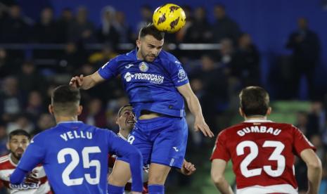 Striker Getafe Borja Mayoral (tengah) menyundul bola selama pertandingan sepak bola LaLiga Spanyol melawan Granada, di Estadio Coliseum, Getafe, Selasa (30/1/2024) dini hari WIB.