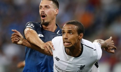 Striker Hoffenheim, Sandro Wagner dihalang-halangi oleh bek Liverpool, Joel Matip pada laga playoff Liga Champions di Rhein Neckar Arena, Rabu (16/8) dini hari WIB. Laga berakhir untuk kemenangan Liverpool, 2-1. 