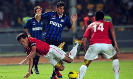   Striker Inter Milan Diego Milito (biru), berusaha melepaskan tendangan melewati hadangan pemain timnas Indonesia, Bima Sakti dalam laga persahabatan Internazionale Milan Indonesia Tour di Stadion Gelora Bung Karno, Senayan, Jakarta, Sabtu (26/5). (Edwin 