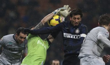 Striker Inter Milan, Diego Milito (tengah) berduel dengan kiper Chievo Christian Puggioni.