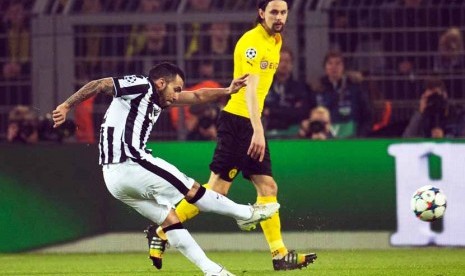 Striker Juventus, Carlos Tevez (kiri), melepaskan tembakan keras menjebol gawang Borussia Dortmund dalam laga ked babak 16 besar Liga Champions di Dortmund, Jerman, Rabu (18/3). 