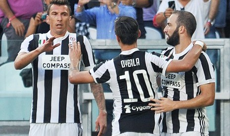 Striker Juventus, Gonzalo Higuain (kanan) merayakan golnya ke gawang Cagliari pada laga Serie A Stadion Allianz, Turin, Sabtu (19/8). Juventus menang 3-0. 