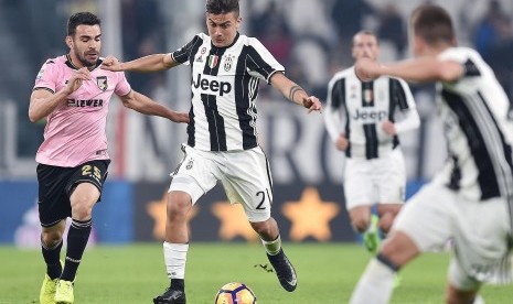 Striker Juventus, Paulo Dybala (tengah) menggiring bola pada laga Serie A lawan Palermo di J-Stadium, Sabtu (18/2) dini hari WIB. Juventus menang 4-1.