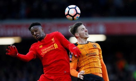 Striker Liverpool Divock Origi (kiri) berebut bola di udara dengan bek Wolverhampton Wanderers, Lee Evans pada laga Piala FA di Anfield, Sabtu (28/1). Liverpool tertinggal dua gol pada babak pertama.