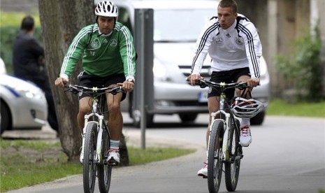 Pesepakbola Jerman Lukas Podolski (kanan) bersepeda. Berlin menambah jalur sepeda selama pembatasan sosial akibat pandemi virus corona. Ilustrasi.