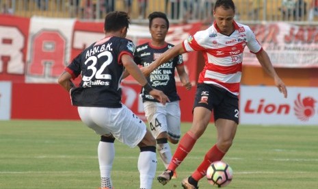 Striker Madura United (MU) FC Peter Osaze Odemwingie (kanan) melewati hadangan pesepak bola Bali United (BU) FC Ahn Byungkeon (kiri) dan I Gede Sukadana dalam (tengah) saat pertandingan Liga 1 di stadion Gelora Pamelingan (SGRP) Pamekasan, Jawa Timur, Ahad (16/4). 