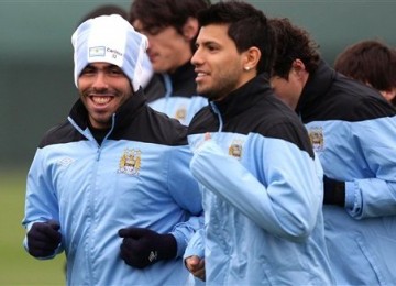 Striker Manchester City, Carlos Tevez (kiri), tersenyum saat menjalani sesi latihan bersama rekan setimnya di Carrington, Manchester, Rabu (14/3). 