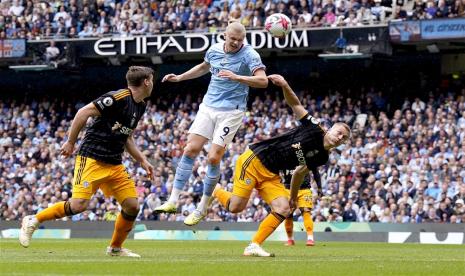 Striker Manchester City Erling Haaland (tengah) menanduk bola tanpa halauan pemain Leeds United di Stadion Etihad, Sabtu (6/5/2023). 