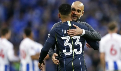 Striker Manchester City, Gabriel Jesus berpelukan dengan pelatih, Pep Guardiola usai memenangkan laga semifinal Piala FA melawan Brighton & Holve Albion di Stadion Wembley, Ahad (7/4) dini hari WIB. City menang 1-0.