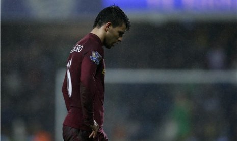 Striker Manchester City, Sergio Aguero, berjalan lesu di bawah guyuran hukan setelah timnya ditahan imbang Queens Park Rangers 0-0 di Loftus Road stadium, London, Selasa (29/1). 