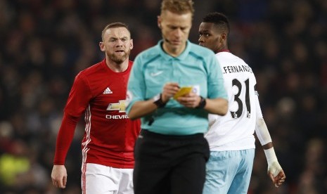 Striker Manchester United, Wayne Rooney (kiri) terlihat kesal setelah dikartu kuning oleh wasit Mike Jones pada laga Piala Liga lawan West Ham United di Old Trafford, Kamis (1/12) dini hari WIB. United menang 4-1 pada laga ini.