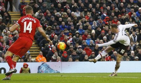 Striker Manchester United, Wayne Rooney, melepaskan tembakan menjebol gawang Liverpool dalam laga Liga Primer Inggris di Stadion Anfield pada Ahad (17/1). 