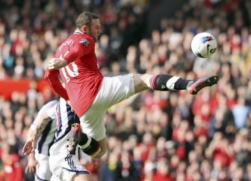 Striker Manchester United, Wayne Rooney, melepaskan tembakan saat menjebol gawang West Bromwich Albion di laga Liga Primer Inggris di Old Trafford, Manchester, Ahad (11/3).