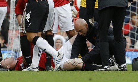 Striker Manchester United, Wayne Rooney, menerima perawatan saat mengalami cedera lutut saat laga menjamu Fulham di Stadion Old Trafford, Manchester, pada 25 Agustus lalu. 