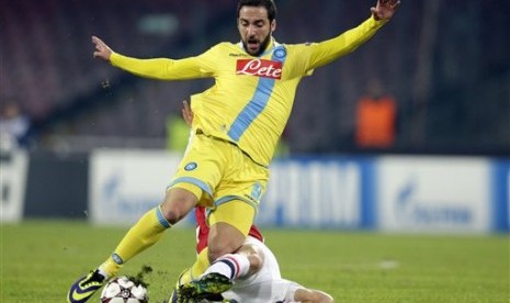 Striker (Napoli) Gonzalo Higuain diganjal seorang pemain Arsenal pada laga penentuan Liga Champions. Meskipun menang, Napoli gagal lolos ke 16 besar.