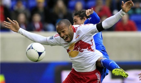 Striker New York Red Bulls, Thierry Henry (depan), terlibat duel dengan pemain Montreal Impact, Zarek Valentin, di laga MLS di Harrison, New Jersey, Amerika. 