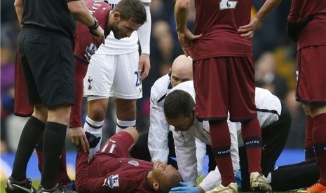 Striker Newcastle United, Yoan Gouffran, terbaring di lapangan saat mendapat pertolongan medis dalam laga Liga Primer Inggris lawan Tottenham Hotspur di White Hart Lane, London, Sabtu (9/2). 