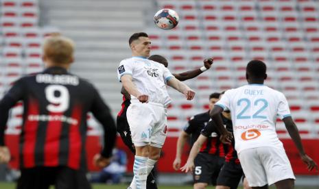 Striker Olimpyque Marseille, Arkadiusz Milik (tengah) menyundul bola pada laga Ligue 1 melawan OGC Nice, di Stadion Allianz Riviera, Sabtu (20/3). Marseille kalah 0-3.