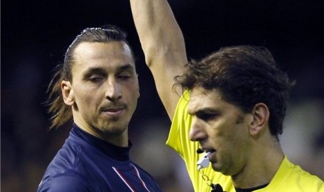 Striker Paris Saint Germain, Zlatan Ibrahimovic (kiri), diganjar kartu merah oleh wasit Paolo Tagliavento pada leg pertama babak 16 besar Liga Champions lawan Valencia di Stadion Mestalla, Valencia, Selasa (12/2). 