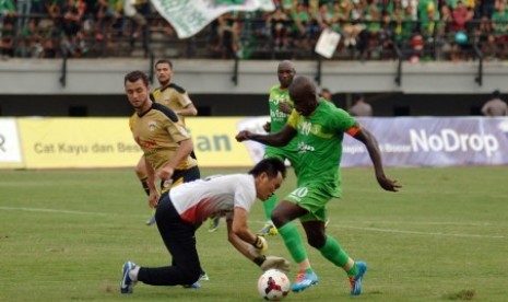 Striker Persebaya Greg Nwokolo berusaha melewati hadangan kiper Mitra Kukar Joice Sorongan pada laga perdana kedua tim di ISL 2014.