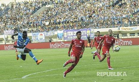 Striker Persib Bandung Ezechiel Ndouasel mencetak gol pertama Persib Bandung saat melawan Persija Jakarta pada laga Liga 1 di Stadion Gelora Bandung Lautan Api, Kota Bandung, Ahad (23/9). 