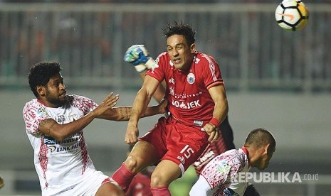 Striker Persija Jakarta Addison Alves De Oliveira (tengah) menyundul bola mendahului dua pesepakbola Persipura Jayapura dalam laga lanjutan Liga 1 di Stadion Pakansari, 